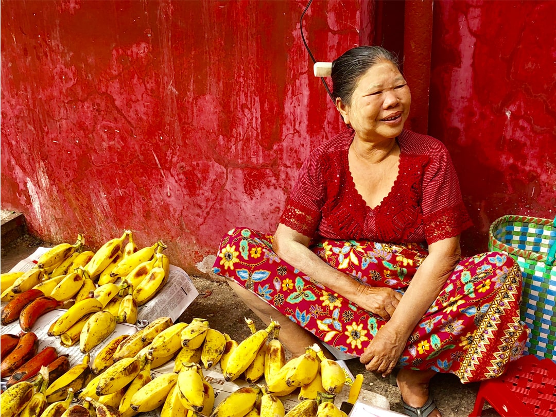 Woman selling fruit in open market.